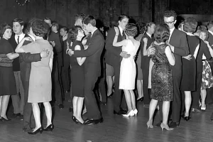 Photo of 1964 students dancing with their partners in a black and white photo.