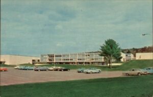 A photo of cars outside school from the 1960s.